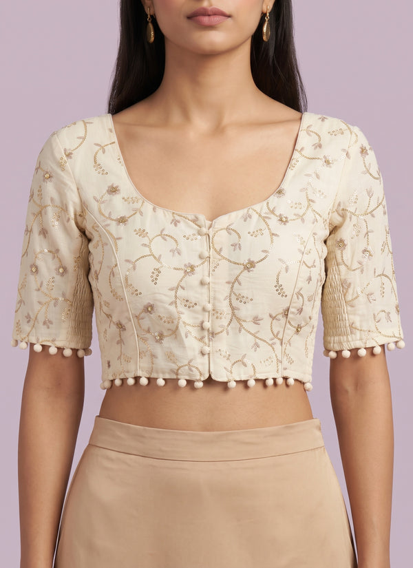 Model wearing the off-white cotton blouse with gold sequin vine jaal embroidery – front