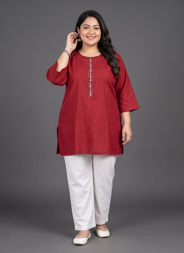Plus size model in a red short kurti with white thread and mirror work placket, front view