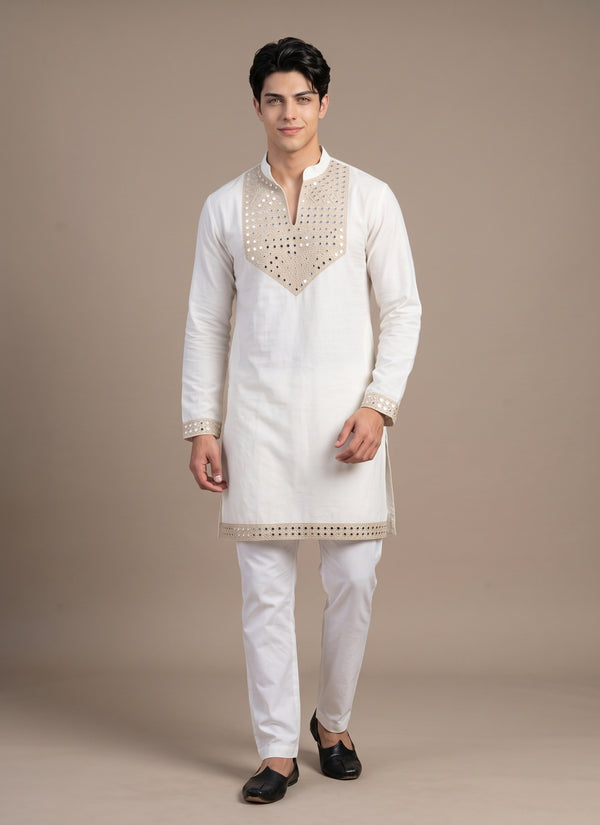 Man wearing a white mirror work kurta pajama for men with heavy mirror yoke, front view