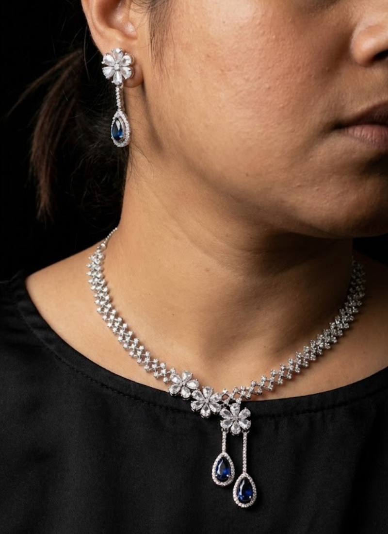 Luxury diamond cut necklace and earring set with high‑quality stone setting and blue gemstone centerpiece.