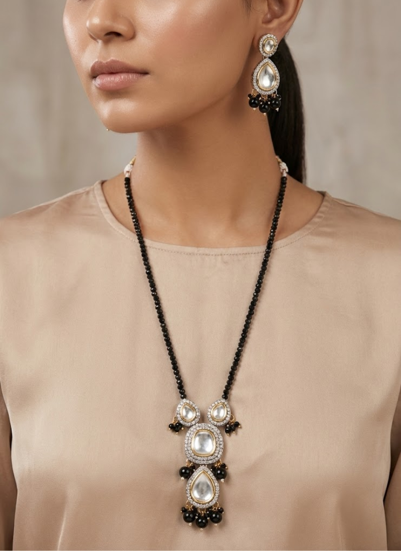 Statement long necklace and earring set in gold finish, kundan and stone setting with black beads.