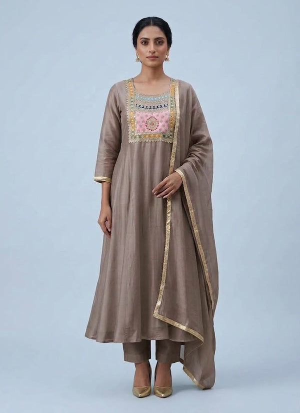 Brown Chanderi Anarkali suit in taupe with light pink zari chest yoke, pants and gold lace dupatta, front view