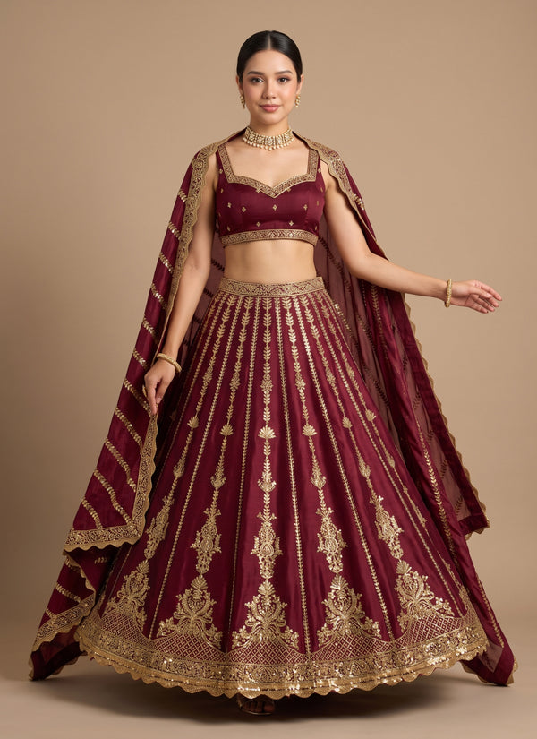 Maroon kasturi silk lehenga choli with gold sequin vines and cape-style dupatta – front flare pose