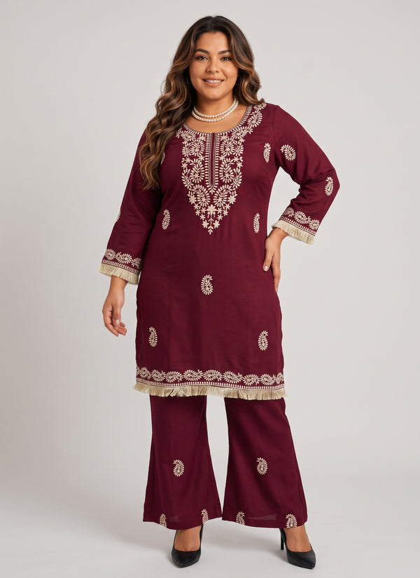 Maroon slub rayon kurti and bell-bottom set with white paisley thread embroidery and fringe lace, worn by a curvy plus-size model, front view