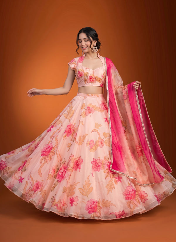 Peach organza lehenga with pink floral print, cap sleeve choli and ombre fuchsia dupatta – front view